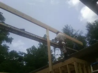 Carpenter setting a ridge beam over a new addition frame — Ice Dam Removal by Roofing Brothers in Hawarden