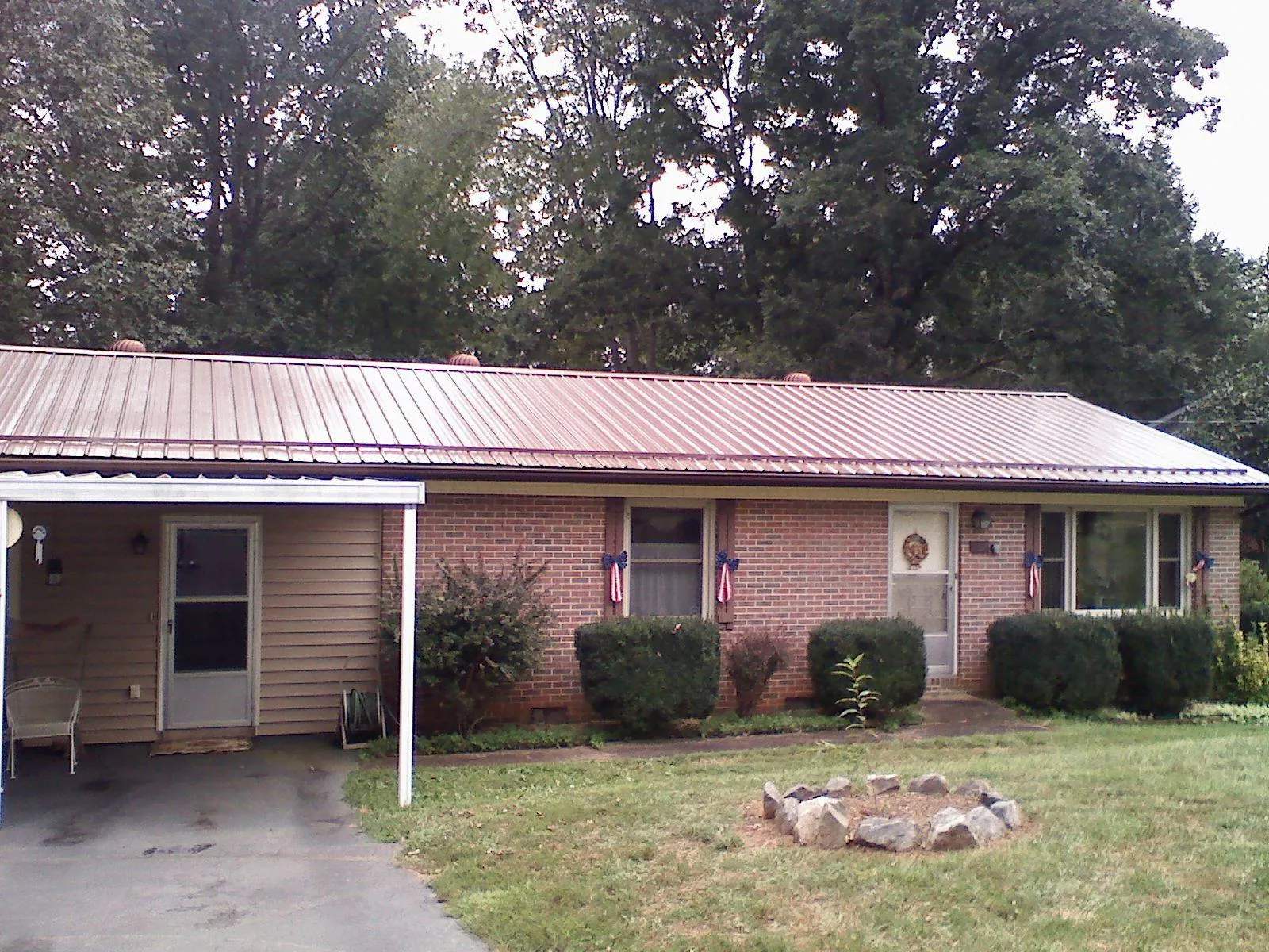 Bronze metal roof and carport on a brick ranch home — Roof Repair work by our crew in Hawarden
